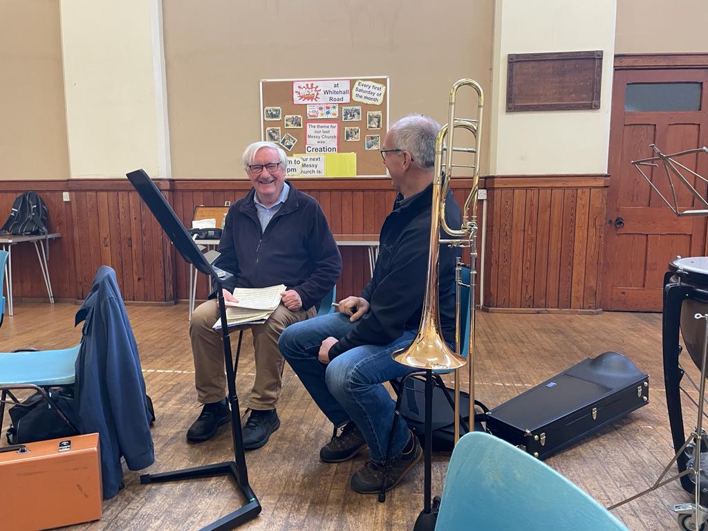 Trombonist and conductor in discussion.